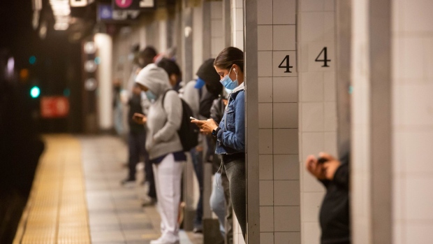 People wearing protective masks wait on a subway platform at Grand Central in New York, U.S., on Monday, Sept. 21, 2020. New York City's Metropolitan Transit Authority reported 8.29 million people entered the subway during the last work week, up 15% from the previous week and 50% lower than the average for the past year.