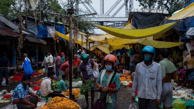 Shoppers wearing protective masks walks past vendors at Mullick Ghat flower market in Kolkata, India, on Tuesday, Sept. 22, 2020. India’s economic recovery prospects have gone from bad to worse after the nation emerged as a new global hotspot for the coronavirus pandemic with more than 5 million infections.