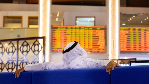An investor watches stock price movements on an electronic screen at the Dubai Financial Market PJSC (DFM) in Dubai, United Arab Emirates, on Sunday, Sept. 6, 2020. Dubai made a rare foray into public bond markets, revealing along the way that its debt burden is now a lot smaller than estimated by analysts only months ago. Photographer: Christopher Pike/Bloomberg
