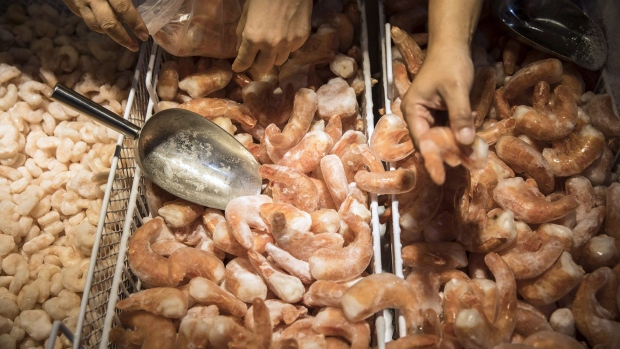 Customers shop for frozen South American shrimp inside a Vanguard hypermarket, operated by China Resources Enterprise Ltd., in Shanghai, China, on Tuesday, Aug. 7, 2018. With trade tensions between the U.S. and China seeming to worsen by the day, mainland companies selling everything from handbags to fresh food are boosting their attempts to cultivate local demand. Photographer: Qilai Shen/Bloomberg