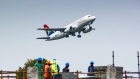 An Airbus A320-200 passenger jet, operated by South African Airlines, flies above a construction site during take-off from O.R. Tambo International Airport in Johannesburg.