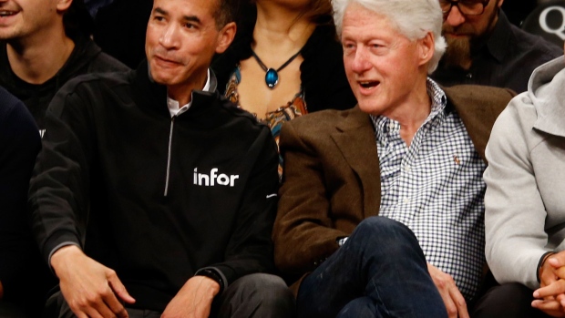 Charles Phillips and former U.S. President Bill Clinton at a basketball game in 2019.