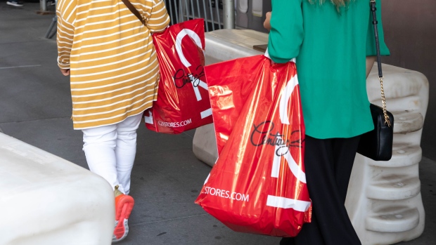 Customers carrying shopping bags outside a Century 21 department store in New York, U.S., on Monday, Sept. 14, 2020. Century 21 Stores, an iconic New York off-price department store chain, filed for bankruptcy with plans to shut down, becoming the latest victim of the retail industry carnage that's accelerated during the pandemic. Photographer: Michael Nagle/Bloomberg
