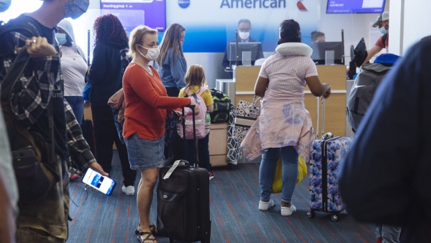 Travelers wearing protective masks wait to board an American Airlines fight at Dallas/Fort Worth International Airport (DFW) in Dallas, Texas, U.S., on Monday, Sept. 28, 2020. Airline passenger numbers in the U.S. totaled 797,699 on Sept. 28, compared with 2.37 million the same weekday a year earlier, according to the Transportation Security Administration.