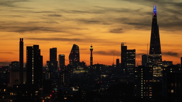 Skyscrapers stand illuminated on the skyline as the sun sets in London, U.K., on Thursday, July 30, 2020.
