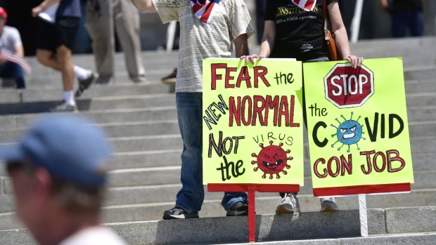 HARRISBURG, PA - MAY 15: Demonstrators with signs stating "FEAR THE NEW NORMAL NOT THE VIRUS" AND "STOP THE COVID CON JOB" rally outside the Pennsylvania Capitol Building to protest the continued closure of businesses due to the coronavirus pandemic on May 15, 2020 in Harrisburg, Pennsylvania. Pennsylvania Governor Tom Wolf has introduced a color tiered strategy to reopen the state with most areas not easing restrictions until June 4. (Photo by Mark Makela/Getty Images)