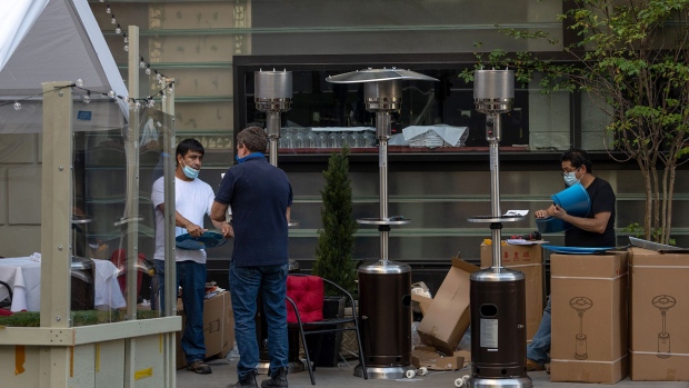Restaurant workers set up outdoor heaters in preparation for cooler weather in New York on Sept. 28.