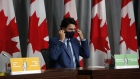 Justin Trudeau puts on a protective mask after an Ottawa news conference on Sept. 25.