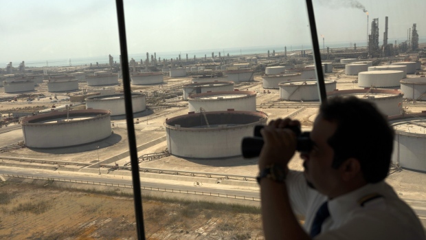 An employee uses binoculars to look out towards the Arabian Sea in the Port Control Center at Saudi Aramco's Ras Tanura oil refinery and terminal in Ras Tanura, Saudi Arabia, on Monday, Oct. 1, 2018.
