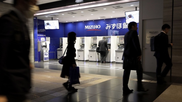 A customer uses an automated teller machine (ATM) at a branch of Mizuho Bank Ltd., a unit of Mizuho Financial Group Inc. (MHFG), in Tokyo, Japan, on Friday, May 10, 2019. Mizuho will announce its year-end earnings figures on on May 15. Photographer: Kiyoshi Ota/Bloomberg