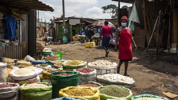 A vendor wearing a protective face mask walks by bags of beans and pulses for sale at Toi market in Nairobi, Kenya, on Tuesday, May 26, 2020. Kenya plans to spend 53.7 billion shillings ($503 million) on a stimulus package to support businesses that have been hit by the coronavirus pandemic, according to the National Treasury. Photographer: Patrick Meinhardt/Bloomberg