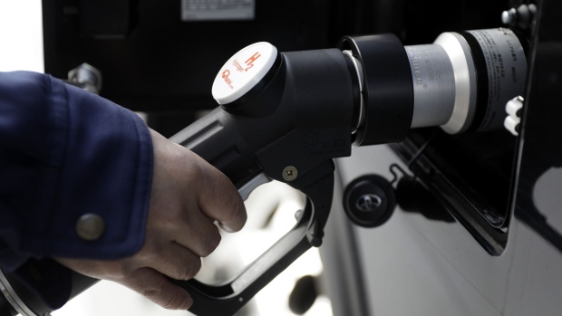 A worker inserts the nozzle of a hydrogen dispenser into a Toyota Motor Corp. Mirai fuel-cell vehicle (FCV) for a photograph during the opening ceremony of the Toyosu Hydrogen Station, jointly built by Tokyo Gas Co. and Japan H2 Mobility LLC (JHyM), in Tokyo, Japan, on Thursday, Jan. 16, 2020. The latest filling station that will be used to service Toyota's fuel cell buses during the 2020 Olympics and Paralympic Games opens Thursday near Tokyo's fish market. Photographer: Kiyoshi Ota/Bloomberg