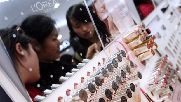 Young Chinese women try out the testers at a L'Oreal SA cosmetics counter at a shopping mall