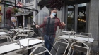 A worker wearing a protective mask carries a plexiglass shield while dismantling a restaurant's terrace in Montreal, Quebec, Canada, on Thursday, Oct. 1, 2020. After a spike in Covid-19 cases, Quebec will force public places including bars, museums, cinemas and restaurant dining rooms to close from Oct. 1 to Oct. 28 in three regions, including greater Montreal and greater Quebec City.