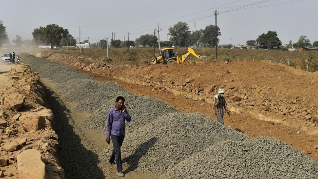 Workers talk on mobile phones at a road construction site in Bhopal District, Madhya Pradesh, India, on Tuesday, Nov. 20, 2018. Key Indian states are voting in polls that may be a preview of next year's national election, with Prime Minister Narendra Modi trumpeting populist welfare schemes to retain power while the opposition works to build alliances that can oust the ruling party. Photographer: Anindito Mukherjee/Bloomberg