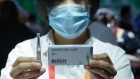 BEIJING, CHINA - SEPTEMBER 05: An employee displaying a coronavirus vaccine candidate from China National Biotec Group (CNBG), during the 2020 China International Fair for Trade in Services (CIFTIS) at Beijing Olympic Park on September 5, 2020 in Beijing, China. As China recovers from the COVID-19 epidemic, about 2,000 Chinese and foreign enterprises will participate and showcase their newest technology in public health and digital technology in the China International Fair for Trade in Services. (Photo by Lintao Zhang/Getty Images)