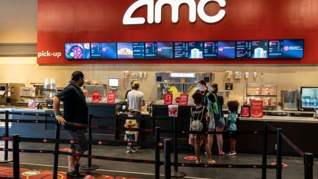 Customers wearing protective masks visit the concession stand at an AMC Entertainment Holdings Inc. movie theater in Austin, Texas, U.S., on Thursday, Aug. 20, 2020. AMC will be reopening more than 100 theaters across the country Thursday, about one-sixth of its locations, with plans to open more in the coming weeks.
