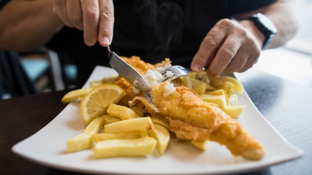 A customer cuts a cod on a plate of fish and chips at a restaurant in Deal, U.K., on Thursday, Oct. 15, 2020. Germany put pressure on France to back down on its demands over fishing, one of the biggest obstacles to a post-Brexit trade deal with the U.K., as Boris Johnson warned he is “disappointed” about the progress of the negotiations.