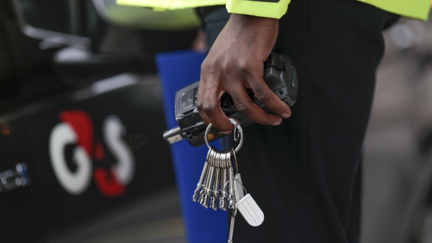 A G4S Plc logo sits on the door of automobile as a security guard holds a set of keys at one of the company's offices in London, U.K., on Monday, Sept. 21, 2020. Harris Associates, one of the largest shareholders in G4S Plc, said it values the U.K. security group "significantly higher" than a roughly 2.9 billion-pound ($3.7 billion) takeover offer from Canadian peer GardaWorld.