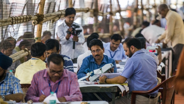 Election officers count votes on Electronic Voting Machines (EVM) at a counting center for the general election in the Govindapuram district of Ghaziabad, Uttar Pradesh, India, on Thursday, May 23, 2019. Indian Prime Minister Narendra Modi is set to win a majority on his own in India's general election, with his Bharatiya Janata Party surging to a commanding lead in early vote counting.