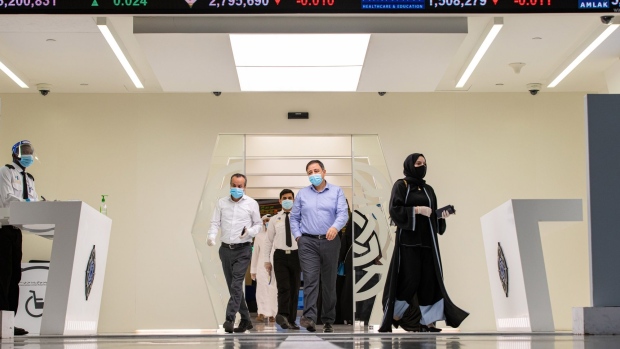 Visitors wearing protective face masks exit the Dubai Financial Market PJSC (DFM) in Dubai, United Arab Emirates, on Sunday, Sept. 6, 2020. Dubai made a rare foray into public bond markets, revealing along the way that its debt burden is now a lot smaller than estimated by analysts only months ago. Photographer: Christopher Pike/Bloomberg