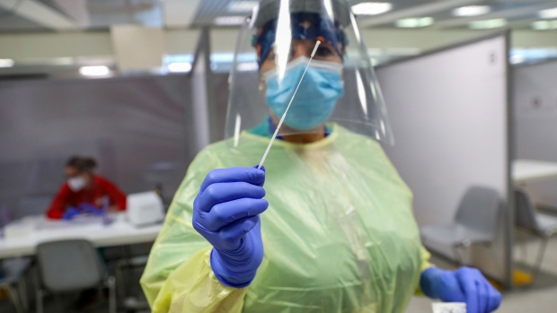 A healthcare worker wearing personal protective equipment (PPE) collects a swab sample from a passenger at the Covid-19 rapid test facility at Fiumicino Airport in Rome, Italy, on Friday, Sept. 25, 2020. A handful of airports are implementing trials of quick-fire coronavirus tests, working with airlines to push technologies still being developed as a way to revive stunted international air travel. Photographer: Alessia Pierdomenico/Bloomberg