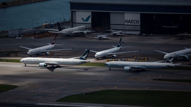 Aircraft operated by Cathay Pacific Airways Ltd. are seen through a barbed-wire fence as they stand parked on the tarmac at Hong Kong International Airport in Hong Kong, China, on Tuesday, June 9, 2020. Cathay became the latest global carrier to seek a lifeline in the aftermath of Covid-19 travel restrictions, outlining a plan to raise HK$39 billion ($5 billion) from the Hong Kong government and shareholders after months of warnings about the frailty of its business. 
