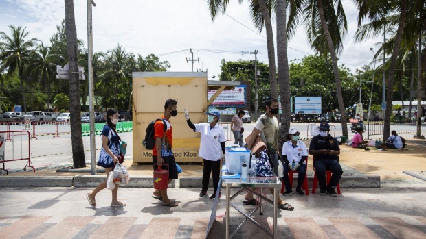 A visitor wearing a protective mask has his temperature checked at an entrance screening point at Bangsaen Beach in Chonburi, Thailand, on Sunday, June 14, 2020. Thailand said a number of countries, including China and Japan, are interested in discussions about travel bubbles, as the nation considers protocols for the eventual return of foreign tourists. Local tourism has already restarted. Photographer: Andre Malerba/Bloomberg