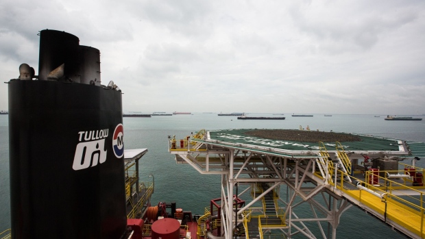 Oil tankers are seen beyond the heli-deck of the Tullow Oil Plc Prof. John Evans Atta Mills Floating Production Storage and Offloading (FPSO) vessel docked at the Sembcorp Marine Tuas shipyard in Singapore, on Thursday, Jan. 21, 2016. The FPSO will receive, process and store crude oil at Tullow's Ten Project oil development around 60 kilometers offshore Western Ghana. The explorer and producer expects its net debt to keep on rising until the Ten Project goes into production in the middle of this year before declining from that point onwards, according to Chief Executive Officer Aidan Heavey. Photographer: Bloomberg/Bloomberg