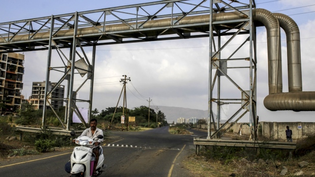 A motorist travels under a Bharat Petroleum Corp. liquefied petroleum gas (LPG) pipeline near the Jawaharlal Nehru Port, operated by Jawaharlal Nehru Port Trust (JNPT), in Navi Mumbai, Maharashtra, India, on Saturday, May 25, 2019. President Donald Trump opened another potential front in his trade war on May 31, terminating India's designation as a developing nation and thereby eliminating an exception that allowed the country to export nearly 2,000 products to the U.S. duty-free.