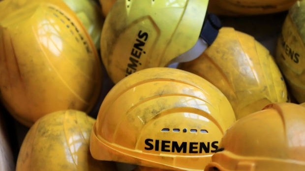 Branded yellow hard hats sit piled inside a Siemens factory in Berlin.