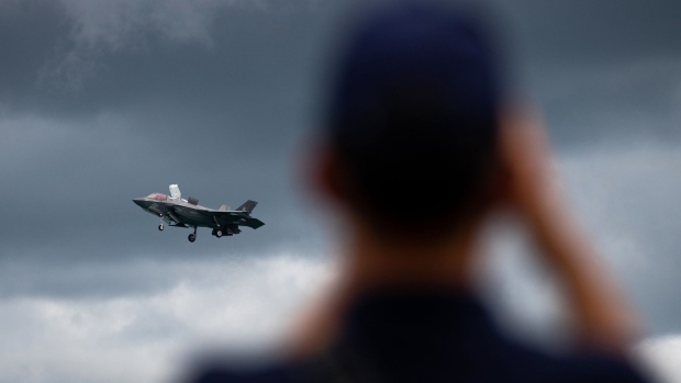 An attendee takes a photograph of a U.S. Marine Corps. F-35B Lightning II fighter jet, manufactured by Lockheed Martin Corp., performing maneuvers during the Singapore Airshow at the Changi Exhibition Centre in Singapore, on Tuesday, Feb. 11, 2020. 