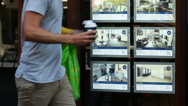 A pedestrian walks past advertisements for residential properties displayed in the window of a real estate agent in Sydney, Australia, on Saturday, Jan. 12, 2019. Prices in Australia's biggest city have tumbled 10 percent and some economists are tipping a similar fall this year. While the central bank isn't panicking just yet, a 15 percent nationwide drop in prices would cut about A$1 trillion ($720 billion) from the housing stock value. Photographer: Brendon Thorne/Bloomberg