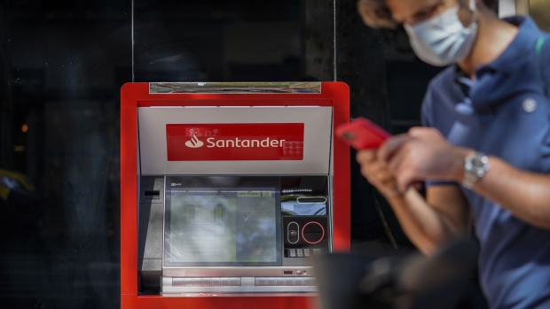 A pedestrian wearing a protective face mask walks past an automated teller machine (ATM) outside a Banco Santander SA bank branch in Madrid, Spain, on Friday, July 24, 2020. Banks in Italy and Spain, among the most exposed to swings in European sovereign bonds, don’t plan to make use of capital relief intended to soften the impact of potential losses from such debt. Photographer: Paul Hanna/Bloomberg