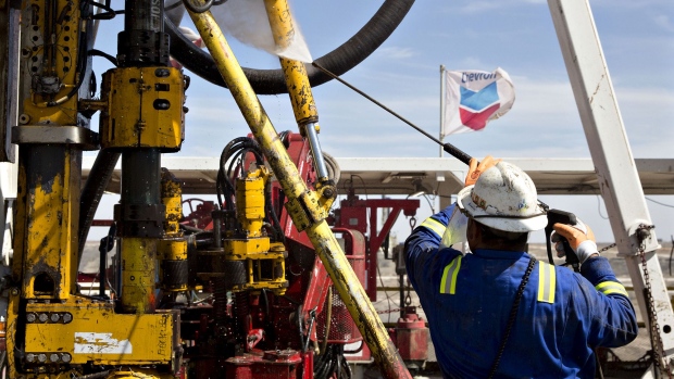 A Nabors Industries Ltd. roughneck uses a power washer to clean the drilling floor of a rig drilling for Chevron Corp. in the Permian Basin near Midland, Texas.
