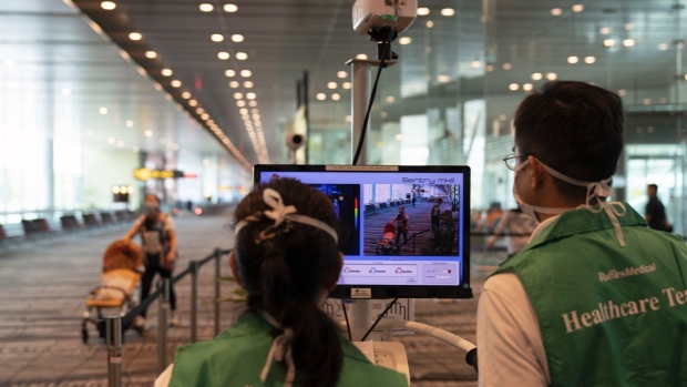 Healthcare officers monitor arriving passengers at a temperature screening point at Terminal 3 of Singapore Changi Airport in Singapore, on Tuesday, March 17, 2020. All arrivals to Singapore from the Asean group of nations as well as Japan, Switzerland and U.K. will have to self-isolate for two weeks in the city-state’s latest measure to tackle the coronavirus pandemic. Photographer: Wei Leng Tay/Bloomberg