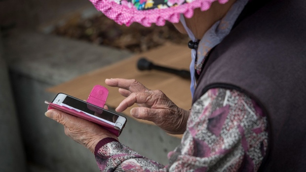 A elderly woman uses an Apple Inc. iPhone in San Francisco, California, U.S., on Tuesday, June 19, 2018. The Labor Department rule, aka the fiduciary rule conceived by the Obama administration, was meant to ensure that advisers put their clients' financial interests ahead of their own when recommending retirement investments has been killed by the Trump administration. Photographer: David Paul Morris/Bloomberg