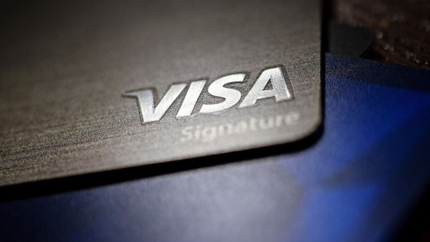 A Visa Inc. credit card is arranged for a photograph in Tiskilwa, Illinois, U.S., on Tuesday, Sept. 18, 2018. Visa and Mastercard agreed to pay as much as $6.2 billion to end a long-running price-fixing case brought by merchants over card fees, the largest-ever class action settlement of an antitrust case.