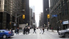 Pedestrians cross a street in the financial district of Toronto, Ontario, Canada, on Friday, Feb. 14, 2020. Canadian stocks declined with global markets, as authorities struggled to keep the coronavirus from spreading more widely outside China. However, investors flocking to safe havens such as gold offset the sell-off in Canada's stock market.