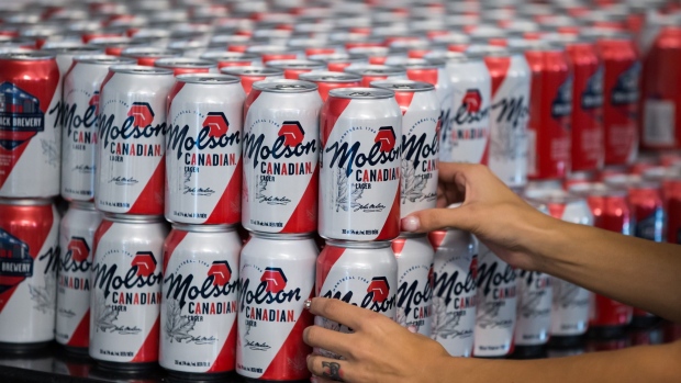 A worker arranges cans of Molson Coors Brewing Co. Canadian beer