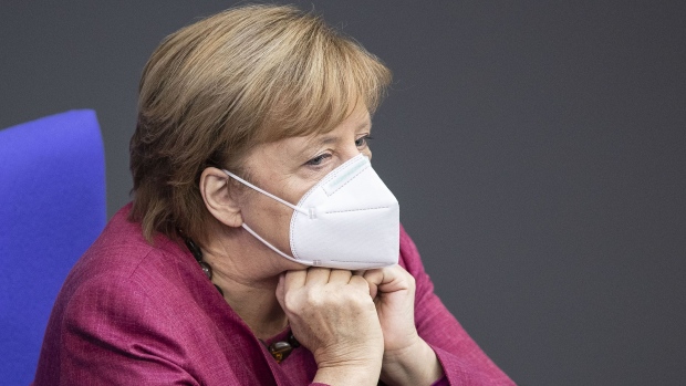 BERLIN, GERMANY - OCTOBER 29: German Chancellor Angela Merkel wears a protective mask as she sits in the Bundestag to outline the government's strategy to cope with the second wave of the coronavirus pandemic on October 29, 2020 in Berlin, Germany. The day before Merkel and the leaders of Germany's 16 states agreed that beginning this coming Monday all restaurants, bars, cultural venues, cinemas and sports facilities will temporarily close. Daily coronavirus infection rates of have recently skyrocketed to up to 15,000. (Photo by Maja Hitij/Getty Images) Photographer: Maja Hitij/Getty Images Europe