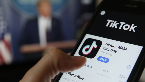 The TikTok app is displayed in the app store in this arranged photograph in view of a video feed of U.S. President Donald Trump in London, U.K., on Monday, Aug. 3, 2020. 