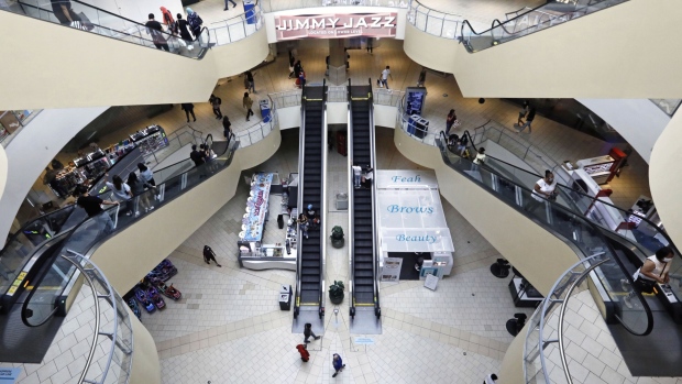 Shoppers walk through the Queens Center shopping mall in the Queens borough of New York, U.S., on Wednesday, Sept. 9, 2020. New York City malls have the green light to reopen Wednesday under the condition that they have enhanced air filtration systems in place. Photographer: Peter Foley/Bloomberg
