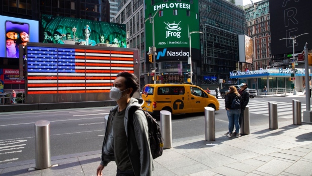Pedestrians wearing protective masks walk past the Nasdaq MarketSite in New York, U.S., on Friday, Oct. 2, 2020. New York faced pressure as middle and high schools reopened, infection rates in virus hot spots rose further and the city's bond rating was cut by Moody's. Photographer: Michael Nagle/Bloomberg