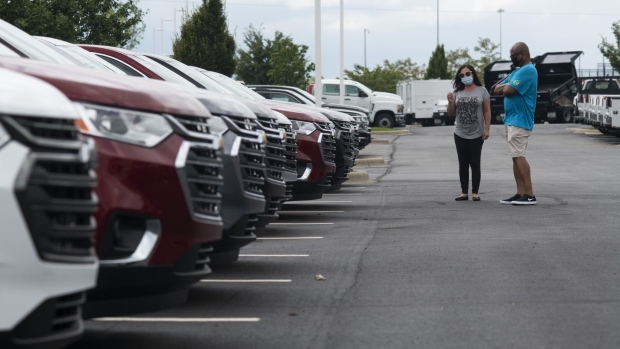 A salesperson and customer wear protective masks while viewing General Motors Co. Chevrolet vehicles displayed for sale at a car dealership in Grove City, Ohio, U.S., on Saturday, Aug. 15, 2020. Sport-utility vehicles and trucks are dominating U.S. auto sales like never before as carmakers start to recover from the biggest shock to their industry in decades. Photographer: Ty Wright/Bloomberg