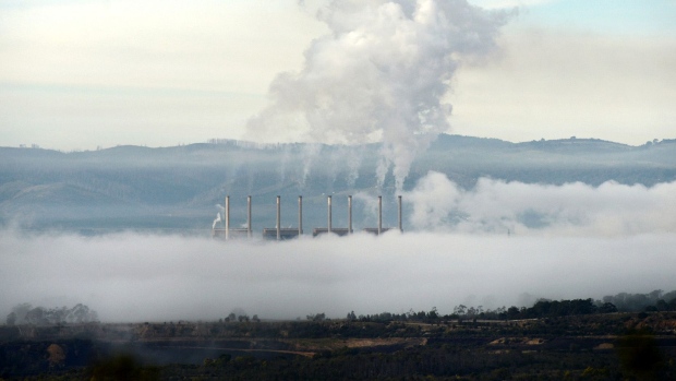 Morning mist surrounds a coal-fired power station as steam billows from the facility's smokestacks in Morwell, Australia.
