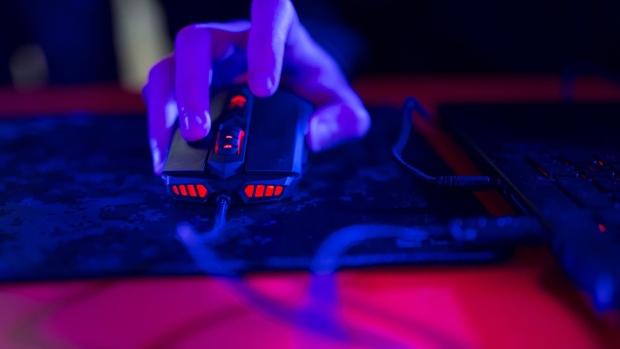 A gamer uses a computer mouse illuminated with red lights while using a laptop computer at the Dreamhack digital festival in Moscow, Russia, on Saturday, Dec. 5, 2015. Dreamhack is the world's largest digital festival and meeting place for gamers, fans and e-sport enthusiasts. Photographer: Bloomberg/Bloomberg