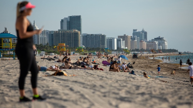People sit on the beach in Miami Beach, Florida, U.S., on Wednesday, June 10, 2020. Delayed by more than a week, Miami-Dade's beaches reopened Wednesday after Mayor Gimenez said he's ending the curfew tied to a string of protests that remained peaceful and largely free of the isolated damage seen on the first night of demonstrations on May 30, according to the Miami-Herald. Photographer: Jayme Gershen/Bloomberg