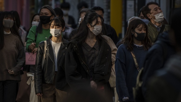 A customer wearing a protective mask uses a smartphone while waiting in line outside an Apple Inc. store in the Omotesando district of Tokyo, Japan, on Wednesday, June 3, 2020. Shuttered after the coronavirus outbreak forced a series of restrictive measures across the country, Apple reopens its flagship stores in Japan on Wednesday, bringing its physical retail network back online in one of its biggest markets. Photographer: Kiyoshi Ota/Bloomberg
