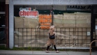 A woman walks past a restaurant closed due to COVID-19, in Vancouver, on May 6, 2020. 